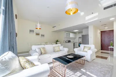 a living room with white couches and a coffee table at Charming 3 BR with walking distance to the Beach in Dubai