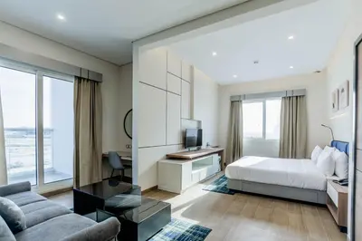 a bedroom with a bed and a tv and a couch at Resivation Hotel in Dubai