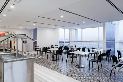 a dining room with tables and chairs and windows at Resivation Hotel in Dubai