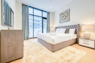 a bedroom with a large bed and a large window at RH- Modern Comfort & bright 1BR near Dubai Mall, City Views in Dubai