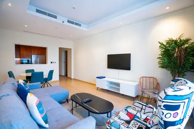 a living room with a blue couch and a tv at RH- Modern Comfort & bright 1BR near Dubai Mall, City Views in Dubai