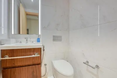 a bathroom with a toilet and a sink and a mirror at RH- Downtown Oasis, Spacious 01 BR in Downtown near Dubai Mall in Dubai
