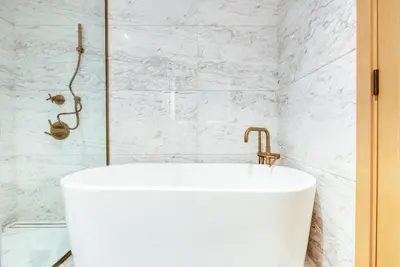 a white tub in a bathroom with a shower at RH- A Stylish Home Away from Home, Spacious 02 BR near Dubai Mall in Dubai