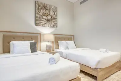 two beds in a room with white walls at RH- A Stylish Home Away from Home, Spacious 02 BR near Dubai Mall in Dubai