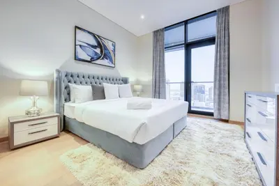 a bedroom with a large bed and a large window at RH- Upscale Living in the Heart of the City, 02BR, Near Dubai Mall in Dubai