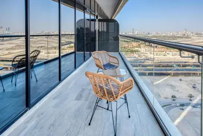 two chairs on a balcony with a view of an airport at RH- Upscale Living in the Heart of the City, 02BR, Near Dubai Mall in Dubai