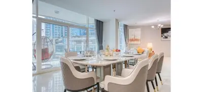 a dining room with a long table and chairs at Luxurious 4-Bedroom Duplex VILLA Apartment near JBR in Dubai