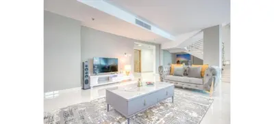a living room with a couch and a tv at Luxurious 4-Bedroom Duplex VILLA Apartment near JBR in Dubai