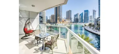 a balcony with a table and chairs and a view of the city at Luxurious 4-Bedroom Duplex VILLA Apartment near JBR in Dubai