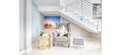 a living room with a chair and stairs at Luxurious 4-Bedroom Duplex VILLA Apartment near JBR in Dubai