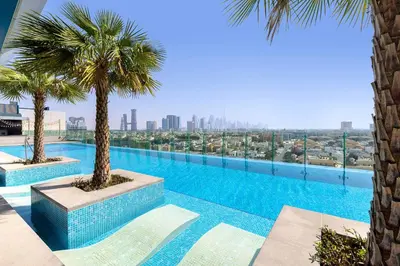 a swimming pool with palm trees on top of a building at Aloft Al Mina, Dubai Jumeirah in Dubai