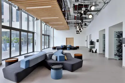 a lobby with couches and tables and windows at Aloft Al Mina, Dubai Jumeirah in Dubai