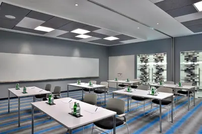 a classroom with tables and chairs and a whiteboard at Aloft Al Mina, Dubai Jumeirah in Dubai