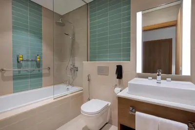 a bathroom with a sink and a toilet and a bath tub at Element Al Mina, Dubai Jumeirah in Dubai