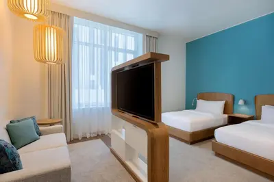 a living room with a tv and a couch and a bed at Element Al Mina, Dubai Jumeirah in Dubai