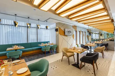 a restaurant with tables and chairs and windows at S19 Hotel-Al Jaddaf Metro Station in Dubai