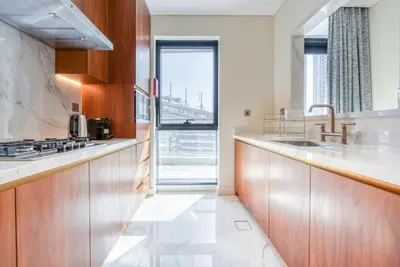 a kitchen with wooden cabinets and a view of a bridge at RH- Downtown Delight, Chic 01BR near Dubai Mall & Burj Khalifa, RP Heights in Dubai