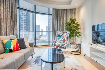 a living room with a couch and a tv at RH- Downtown Delight, Chic 01BR near Dubai Mall & Burj Khalifa, RP Heights in Dubai