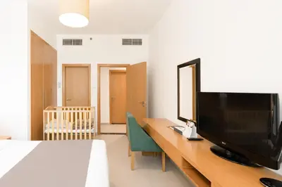 a bedroom with a desk with a flat screen tv at Grand Heights Dubai Hotel Apartments in Dubai
