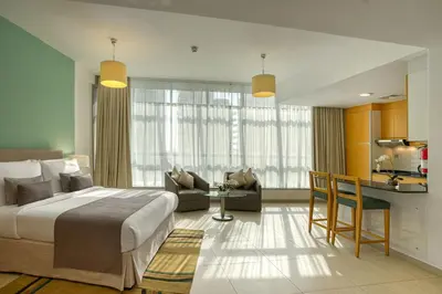 a hotel room with a large bed and a kitchen at Grand Heights Dubai Hotel Apartments in Dubai