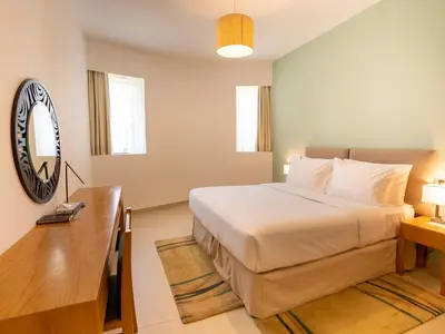 a bedroom with a large bed and a mirror at Grand Heights Dubai Hotel Apartments in Dubai