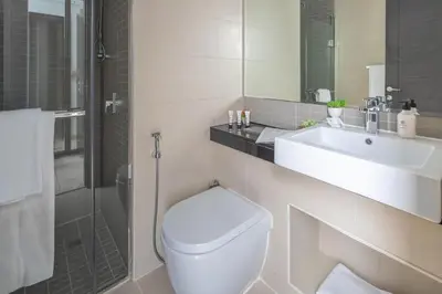 a bathroom with a toilet and a sink and a shower at Frank Porter - Silverene in Dubai
