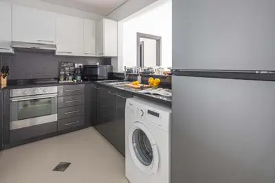 a kitchen with a washing machine and a washer at Frank Porter - Silverene in Dubai