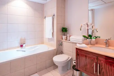 a bathroom with a tub and a toilet and a sink at Elite Royal Apartment - Full Burj Khalifa & Fountain View - Emerald in Dubai