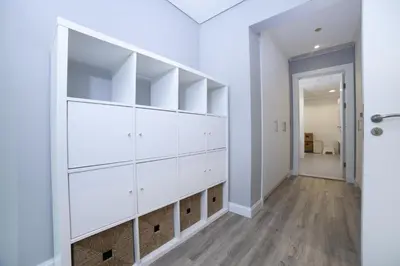 a room with white shelves and a hallway at Lux 2BR in Al Khushkar Shoreline -Palm Jumeirah in Dubai