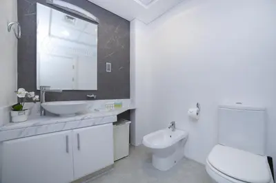 a white bathroom with a sink and a toilet at Lux 2BR in Al Khushkar Shoreline -Palm Jumeirah in Dubai