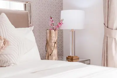 a bedroom with a bed with a lamp and pink flowers at Elite Royal Apartment - Full Burj Khalifa & Fountain View - Ruby in Dubai