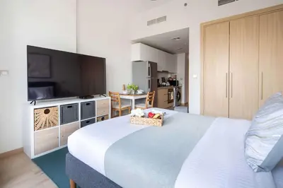 a bedroom with a large bed and a television at Frank Porter - Azizi Aura in Dubai