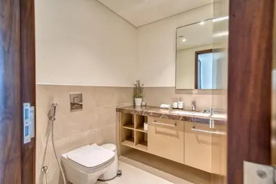 a bathroom with a toilet and a sink and a mirror at Boho-Chic Cosy 1BR, minutes to Burj Khalifa in Dubai