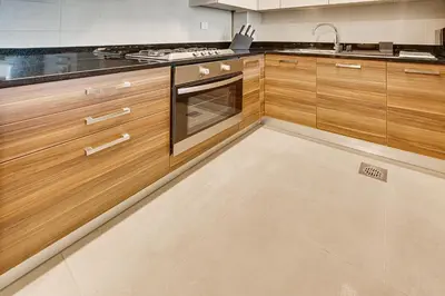 a kitchen with wooden cabinets and a stove at 1BD apt in Sparkle Tower by Swarovsky big capacity in Dubai
