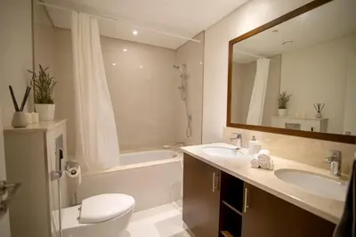 a bathroom with a sink and a toilet and a mirror at Elegant Apt With Balcony Minutes from Burj Khalifa in Dubai