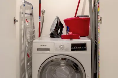 a washing machine with a bucket on top of it at Elegant Apt With Balcony Minutes from Burj Khalifa in Dubai