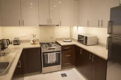 a kitchen with a stove and a microwave at Elegant Apt With Balcony Minutes from Burj Khalifa in Dubai