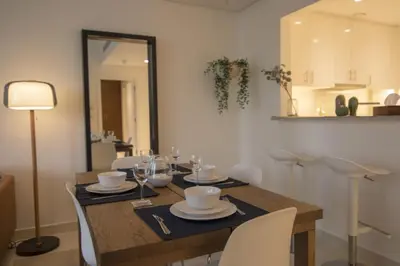 a dining room with a table with chairs and a mirror at Elegant Apt With Balcony Minutes from Burj Khalifa in Dubai