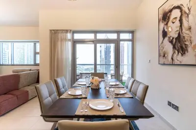 a dining room with a table and chairs and a couch at Scenic 2 Bedroom Apartment - Downtown Business Bay in Dubai