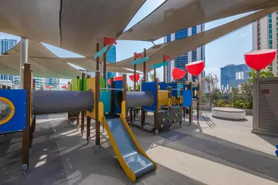 a playground with a slide and play equipment at Bespoke Holiday Homes - Mag 318 Downtown Dubai in Dubai