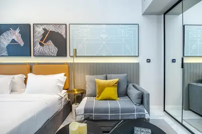 a bedroom with a bed and a chair at Bespoke Holiday Homes - Mag 318 Downtown Dubai in Dubai