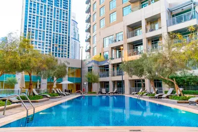 a swimming pool in the courtyard of a building with tall buildings at Holidays R Us canal view in Dubai