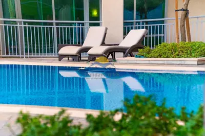 a group of chairs sitting next to a swimming pool at Holidays R Us canal view in Dubai