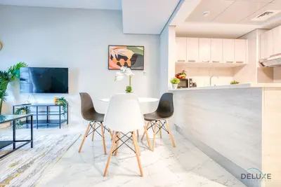 a kitchen and dining room with a table and chairs at Snug 1BR at MAG 520 Dubai South by Deluxe Holiday Homes in Dubai