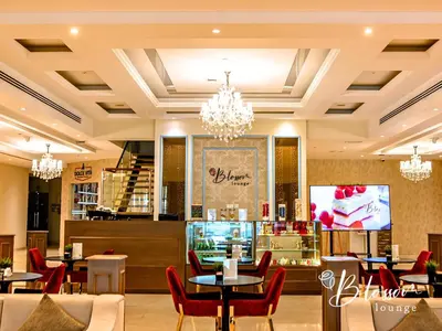a restaurant with tables and chairs and a chandelier at Asma Hotel Al Barsha in Dubai