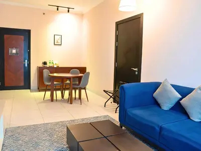 a living room with a blue couch and a table at Asma Hotel Al Barsha in Dubai