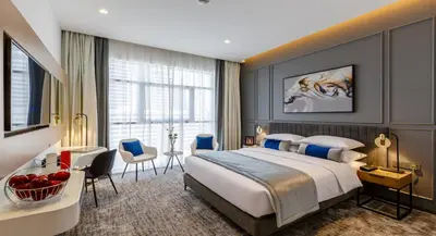 a hotel room with a bed and a desk and chairs at Rose Executive Hotel - DWTC in Dubai