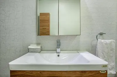 a bathroom with a white sink and a mirror at Live Modern Live Luxury - Dubai Studio City in Dubai