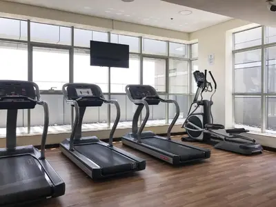 a gym with four exercise bikes and a flat screen tv at Frank Porter - The Medalist in Dubai