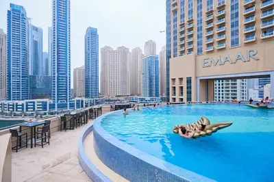 a woman laying in a swimming pool on top of a building at Exquisite 1BR at The Address Residences Dubai Marina by Deluxe Holiday Homes in Dubai